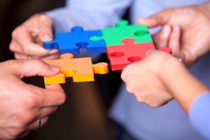 Group of business people assembling jigsaw puzzle and